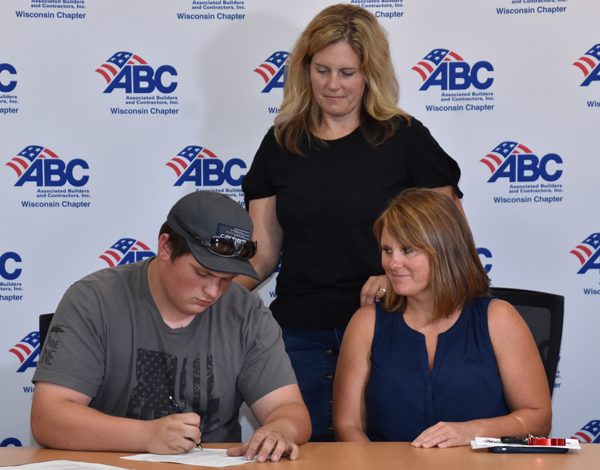 Apprentice signing document with employees