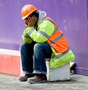 construction worker sitting down with head in hands