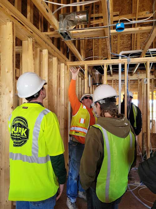 Brian Steinhoff shows students fire protection and HVAC equipment in the stacked flats units.