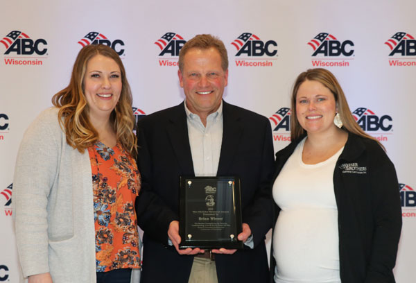 Photo of Brian Wieser, his daughters and the Wes Meilahn Award.