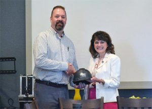 man and woman shaking hands with ABC hard hat