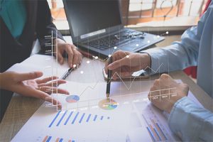 two people sitting down looking at charts