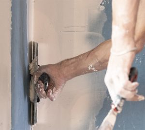 man applying mud to drywall