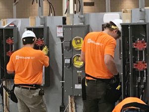 two men working on electrical panels