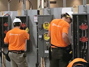 two men working on electrical panels