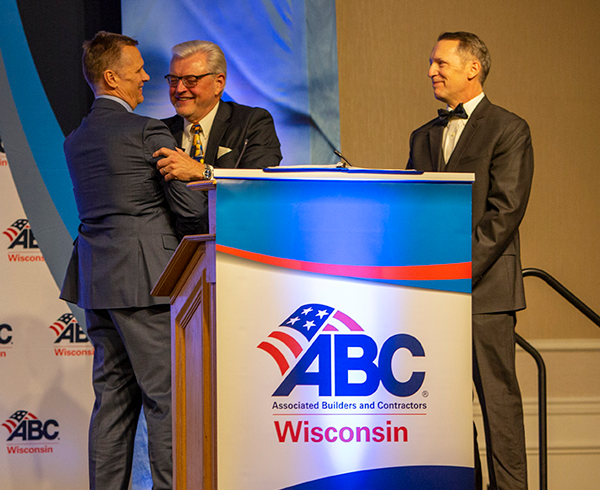 Jay Zahn (left) congratulates Steve Klessig for receiving the Wes Meilahn Award as Kyle Schwarm (right) looks on.