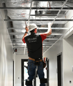 Ceiling finisher using stilts to reach his work at WVRC project in Mequon